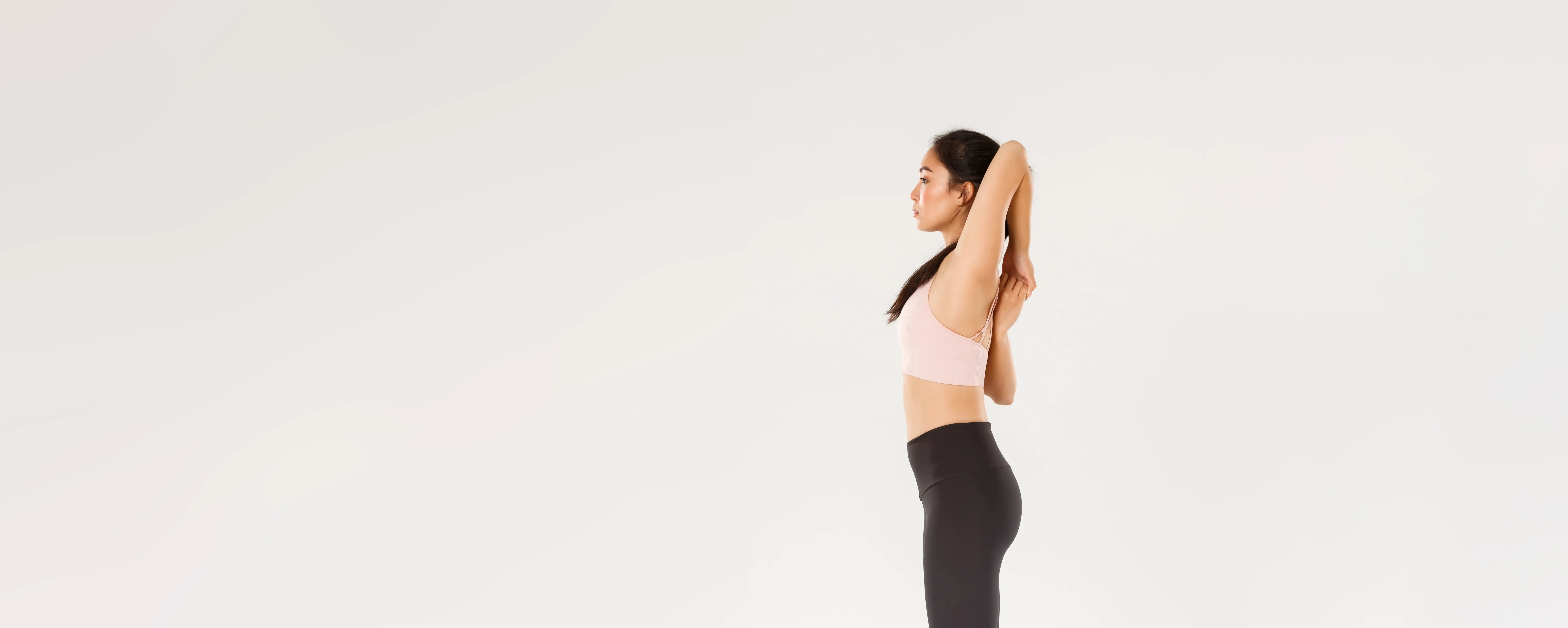 Full length profile of focused strong asian female coach sportswoman doing fitness