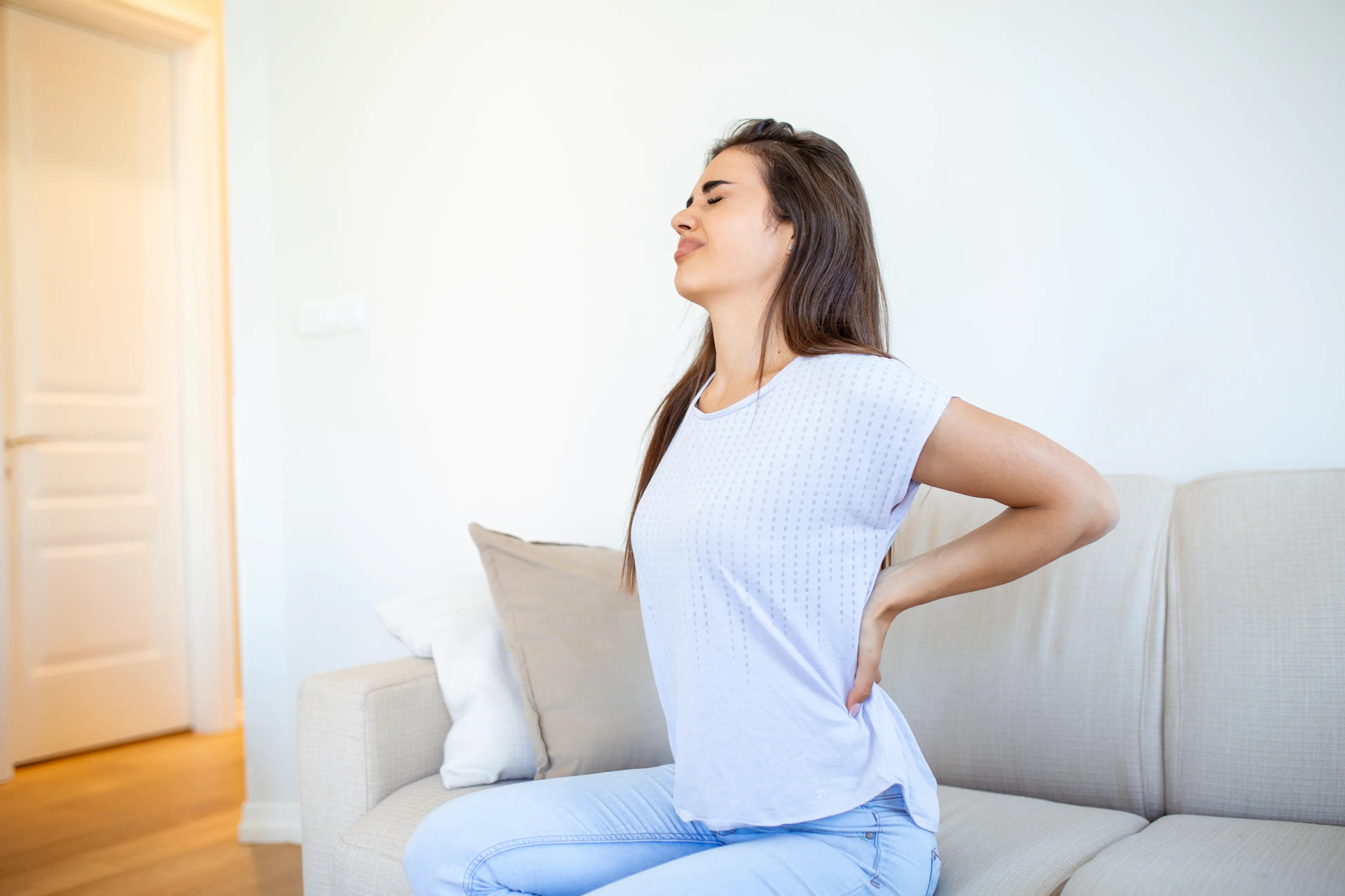 Woman suffering from backache at home lower back pain woman feels back pain